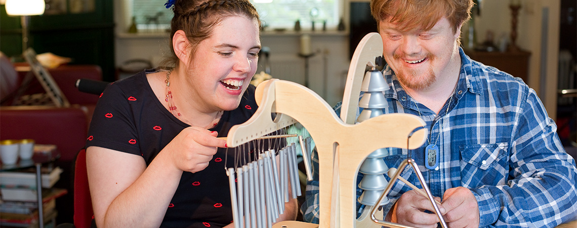 Op deze foto ziet u twee jongeren met een cognitieve beperking spelen met de Trisun. De Trisun maakt deel uit van een serie muziekinstrumenten speciaal ontwikkeld voor jongeren met een beperking en ouderen met dementie. Op de foto ziet u dat muziek maken ook voor mensen met een beperking een heerlijke bezigheid is.